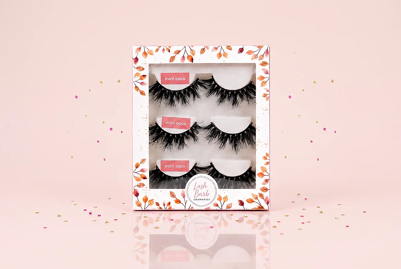 Mini Coco 3-pack strip lashes box on a seamless soft blush pink backdrop with warm cream undertones and subtle glossy reflection